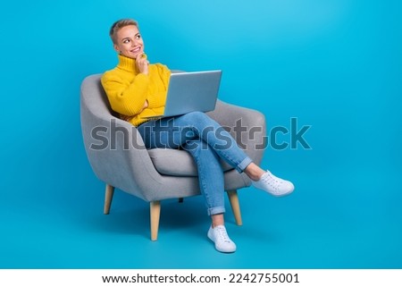 Full body photo of attractive blonde hair entrepreneur touch chin look empty space sit chair think amazon shop isolated on blue color background
