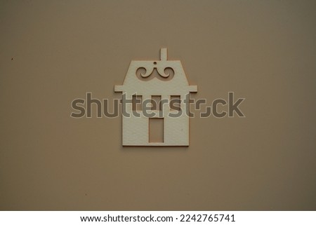 Flat wooden house on biege background view from above. The concept of buying your own home. Creative home ownership concept. Real estate related concept. Dream house offer concept.