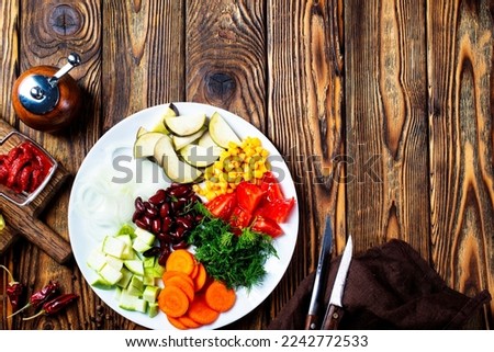 fresh vegetables: eggplants, beans, leek, tomatoes, chili peppers, carrot, garlic, onion on old wooden background, rustic style, top view