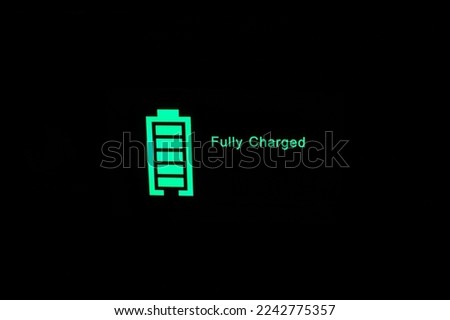 "Fully charged" Glowing green battery charge indicator. Fast charging technology. Royalty-Free Stock Photo #2242775357