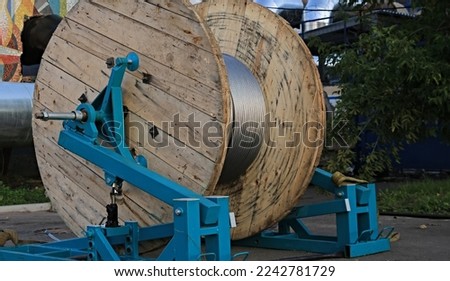 background wooden drum with electric cable Royalty-Free Stock Photo #2242781729