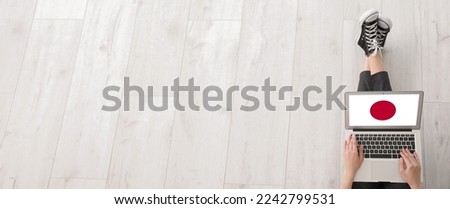 Woman using laptop for studying Japanese language on light wooden background with space for text
