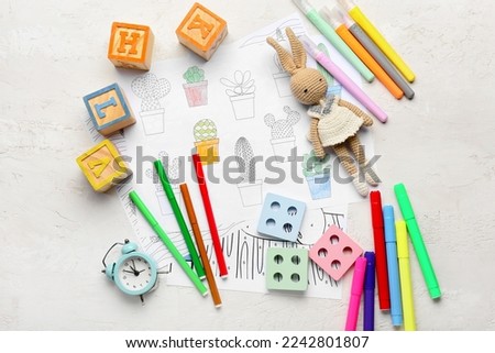 Coloring pages, felt-tip pens and toys on white background