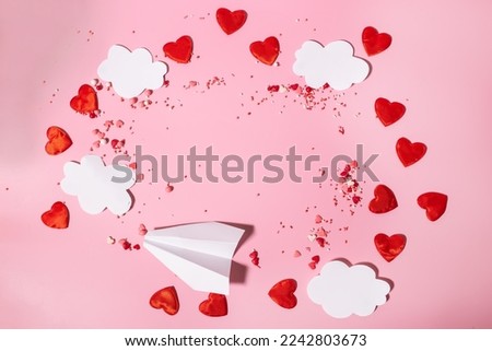 A frame of paper clouds, hearts and a paper airplane for Valentine's Day commercials