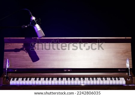 condenser microphone over classical vintage piano on black. music background or piano recording concept