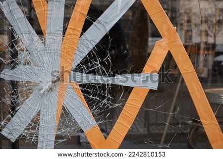 broken glass fixed with masking tape , riot in Paris