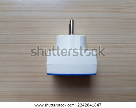 Electric plug on wooden table background.