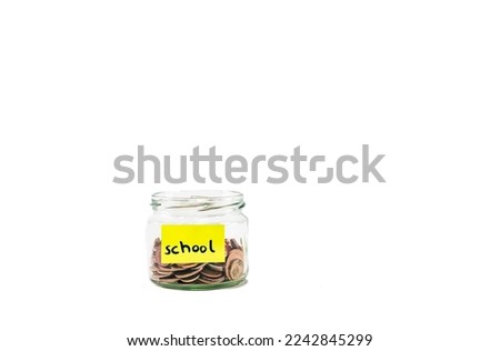 Close up glass jar with coins, moneybox, penny or piggy bank. Saving money euro coin for  school, college or university. Saving money penny bank on white background. Yellow school sticker on it.