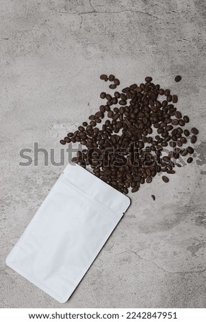 Coffee beans and eco packaging isolated on gray background.