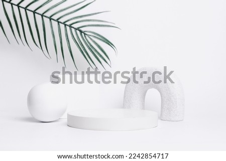 Abstract background with various geometrical forms and podiums in white color and green palm leaves for product presentation. Podium to show cosmetic products.