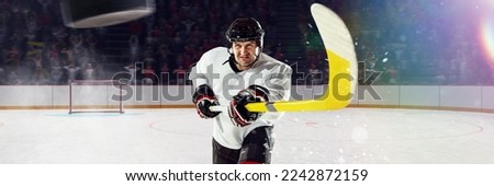 Man, professional hockey player in motion, playing, training over ice rink. Motivated and concentrated sportsman. Concept of sport, action, game, strength, championship and competition.