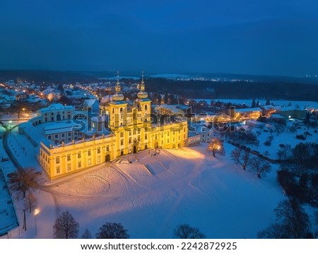 Aerial, late evening view of illuminated Minor Basilica of the Visitation of the Virgin Mary, pilgrimage church covered with snow. Blue hour, pastel colors, Christmas time, Moravia, Czech republic.