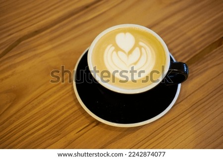 Latte with a heart on a wooden table.