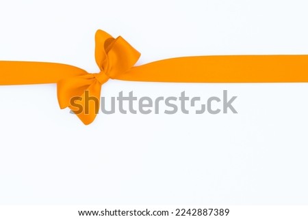 Satin ribbon bow for gift pack in yellow color, isolated on white background. Background with ribbon bow on white background.