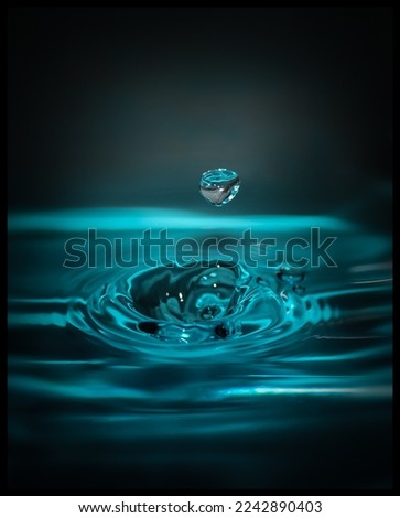 A digitally enhanced photograph of a droplet of water causing ripples after hitting the surface.