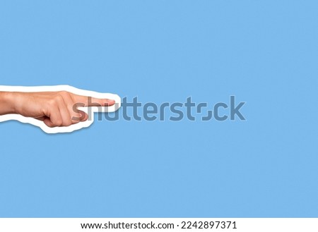 Hand pointing finger on blue background in collage cut out style with plenty of copy space
