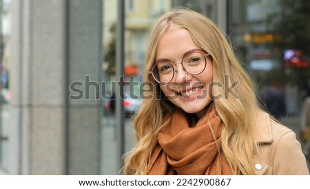 Close up female outdoors smiling laughing Caucasian woman smile looking at camera girl blonde model with healthy white teeth happy lady with glasses posing on street in city attractive student outside