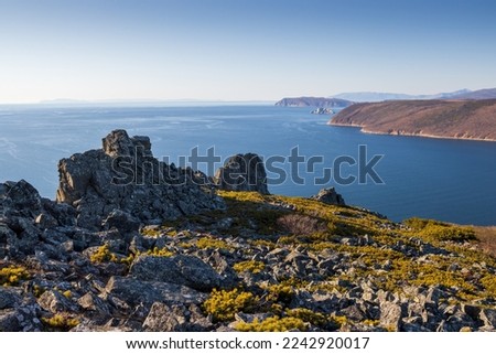 View of the rocks, the sea and the coast. Autumn landscape. Nature of Siberia and the Russian Far East. Travel, tourism and hiking in the Magadan region. Stone Crown Mountain. Sea of Okhotsk, Russia. Royalty-Free Stock Photo #2242920017