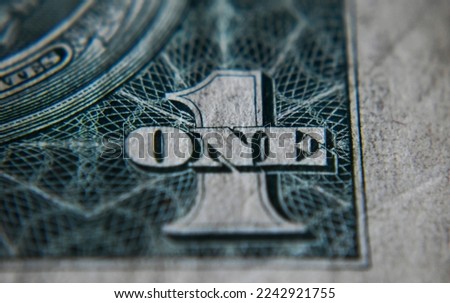 One sign in focus over currency notes.