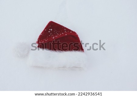 Santa claus hat hanging in the snow,                   