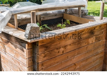 Planted raised bed in spring in your own garden - self-made cold frame Royalty-Free Stock Photo #2242943975