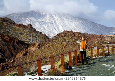 Winter in Teide National Park. Nature photographer taking pictures of Teide volcano covered with snow. Tenerife,
Canary Islands, Spain. Selective focus.