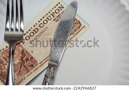 Food coupon on a paper plate with fork and knife Royalty-Free Stock Photo #2242966827