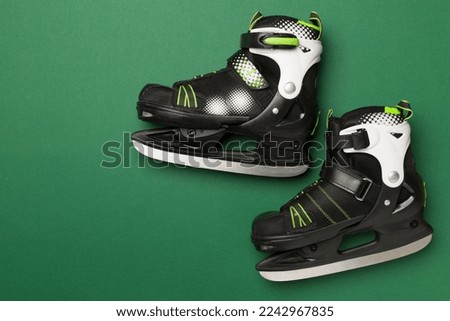 Ice skates on color background, top view