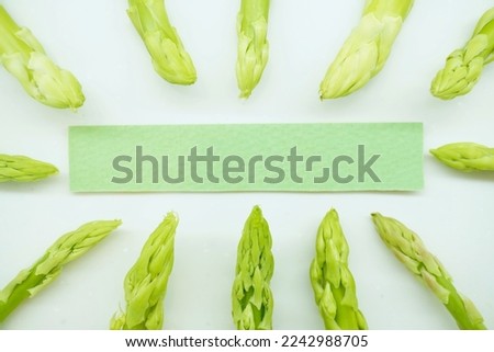 Mock-up of green spears of asparagus lined up and green card comment frame