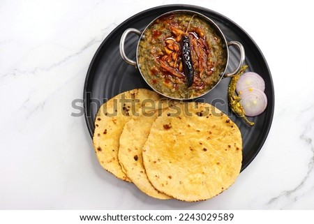 Sarson ka saag and Makke di roti. mustard leaves curry. It's a popular Punjabi winter dish made using corn meal and mustard leaves. served with onions and green chili. with copy space. Royalty-Free Stock Photo #2243029589