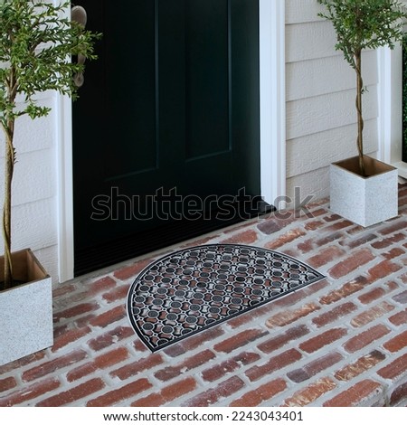 Designer Welcome Entry Doormat Placed on Solid Brick Floor Outside Entry Door with Plants
