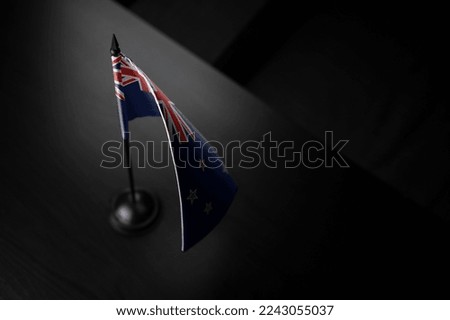 Small national flag of the New Zealand on a black background.