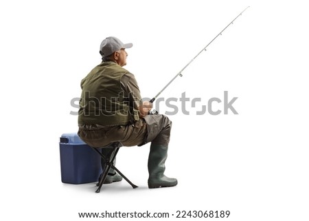 Fisherman sitting on a chair with a fishing rod isolated on white background Royalty-Free Stock Photo #2243068189