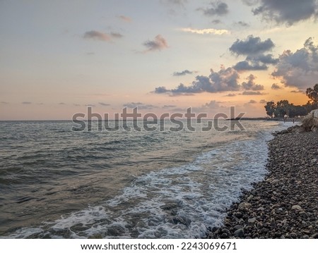 Sunset on the Mediterranean Sea in Turkey. The setting sun reflects on the waves of the sea. Coast of the sea during sunset in late autumn.