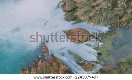 Nature concept. Wildlife. Turquoise water. A fast waterfall flows from a cliff. Top view. Aerial drone view. High quality photo