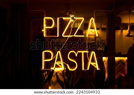 Neon yellow pizza pasta street sign.