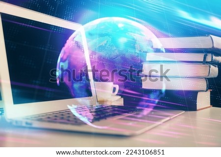 Computer on desktop in office with technology theme hologram. Double exposure. Tech concept.