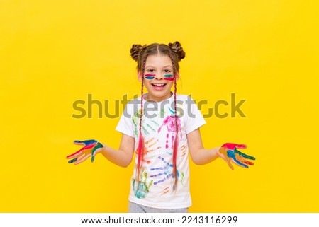 Art drawing for children. A small smiling girl on a yellow isolated background . The child got his hands dirty in paint. Drawing courses for children. Royalty-Free Stock Photo #2243116299