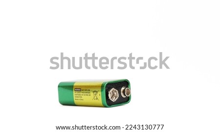 9 volt alkaline battery isolated on white background. 9 V (PP3) alkaline battery. Plus and minus poles resembling a pair of eyes. Copy space, space for text. No people, nobody. Metaphor. Royalty-Free Stock Photo #2243130777