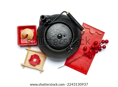 Teapot, fortune cookie, red envelope and Chinese symbols on white background. New Year celebration Royalty-Free Stock Photo #2243130937