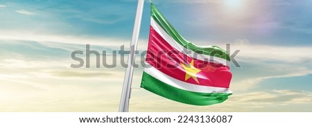Suriname Flag on pole for Independence day. The symbol of the state on wavy cotton fabric.