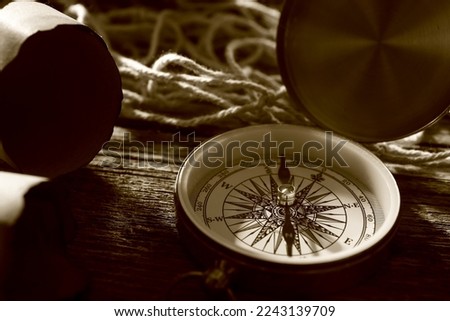 Compass and maps on dark wooden background, closeup