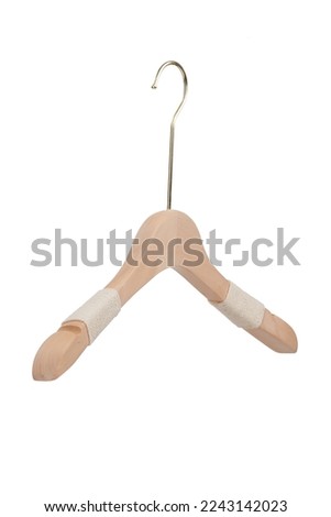 Close-up shot of a natural wooden hanger with notches for hanging tank tops or dresses and non-slip cotton finish. A clothes hanger is isolated on a white white background. Side view. Royalty-Free Stock Photo #2243142023