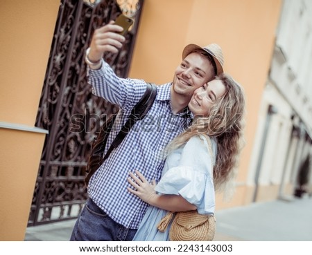 Young couple tourists makes a selfie on smartphone on European street