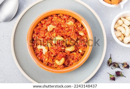 Gajar ka halwa is, Popular Indian dessert pudding made with grated carrots, milk, sugar and nuts served hot with a garnish of almonds, cashew nuts and pistachios. Royalty-Free Stock Photo #2243148437