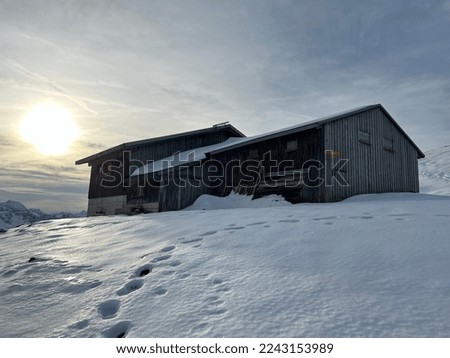Indigenous alpine huts and wooden cattle stables on Swiss pastures covered with fresh first snow cover in the Alpstein mountain massif, Urnäsch (Urnaesch or Urnasch) - Canton of Appenzell, Switzerland