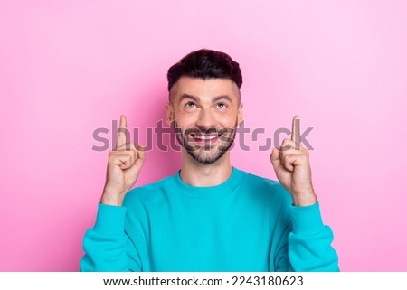 Photo of optimistic guy brunet hair guy wear cyan pullover direct fingers up empty space useful tips promo advert isolated on pink color background
