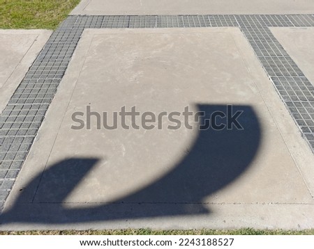 Floor with decorative grid in the patio of the house, with shadow of the luminaire in a curved shape, forms an original abstract design with a background of the gray surface