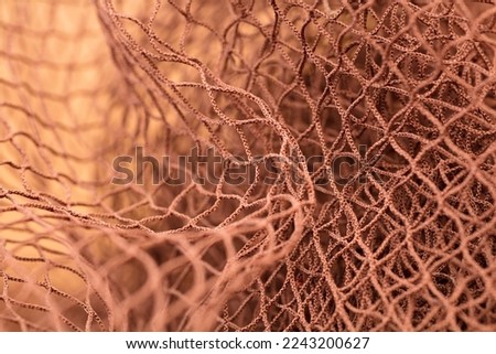 Brown fishing net, on soft brown background