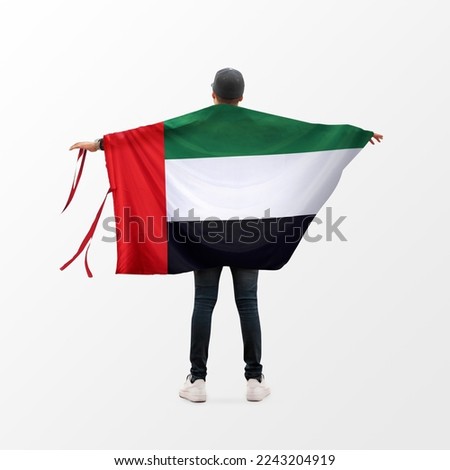 Young man holding Uae Flag in White Background, Flag of United Arab Emirates.